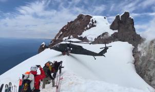 Un helicóptero consigue equilibrarse en la cima de una estrecha montaña para un rescate